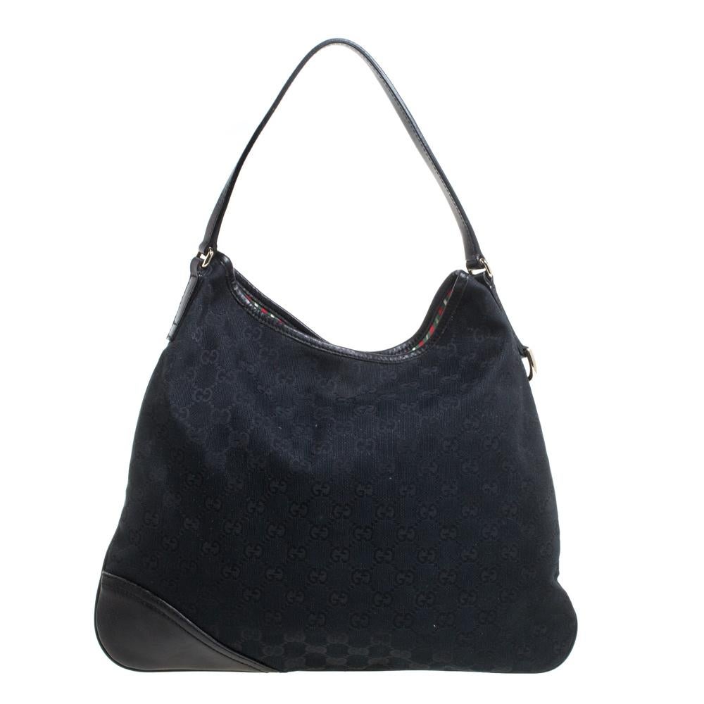 Keep your look refined and casual with this New Britt hobo by Gucci. Made from black GG canvas and leather, it is accented with a gold-tone GG logo at the corner. The creation comes with a single shoulder strap and a magnetic snap closure. The large
