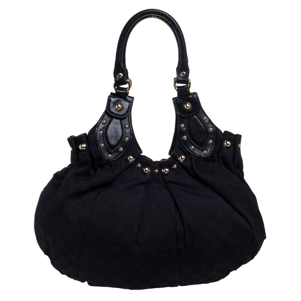 This Gucci black Pelham hobo for women comes fashioned with GG canvas and leather. It has an exterior laid with gold-tone studs and they form a fine outline. The spacious bag is lined with fabric and held by two handles.

