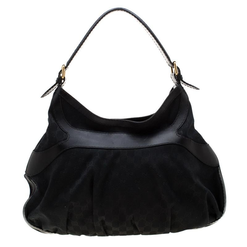 This feminine and luxe Queen hobo by Gucci is great for a casual day look. The exterior is crafted from GG coated canvas with smooth leather trim, that is accented with large gold-tone bow buckle at the front. The interior is lined with fabric that