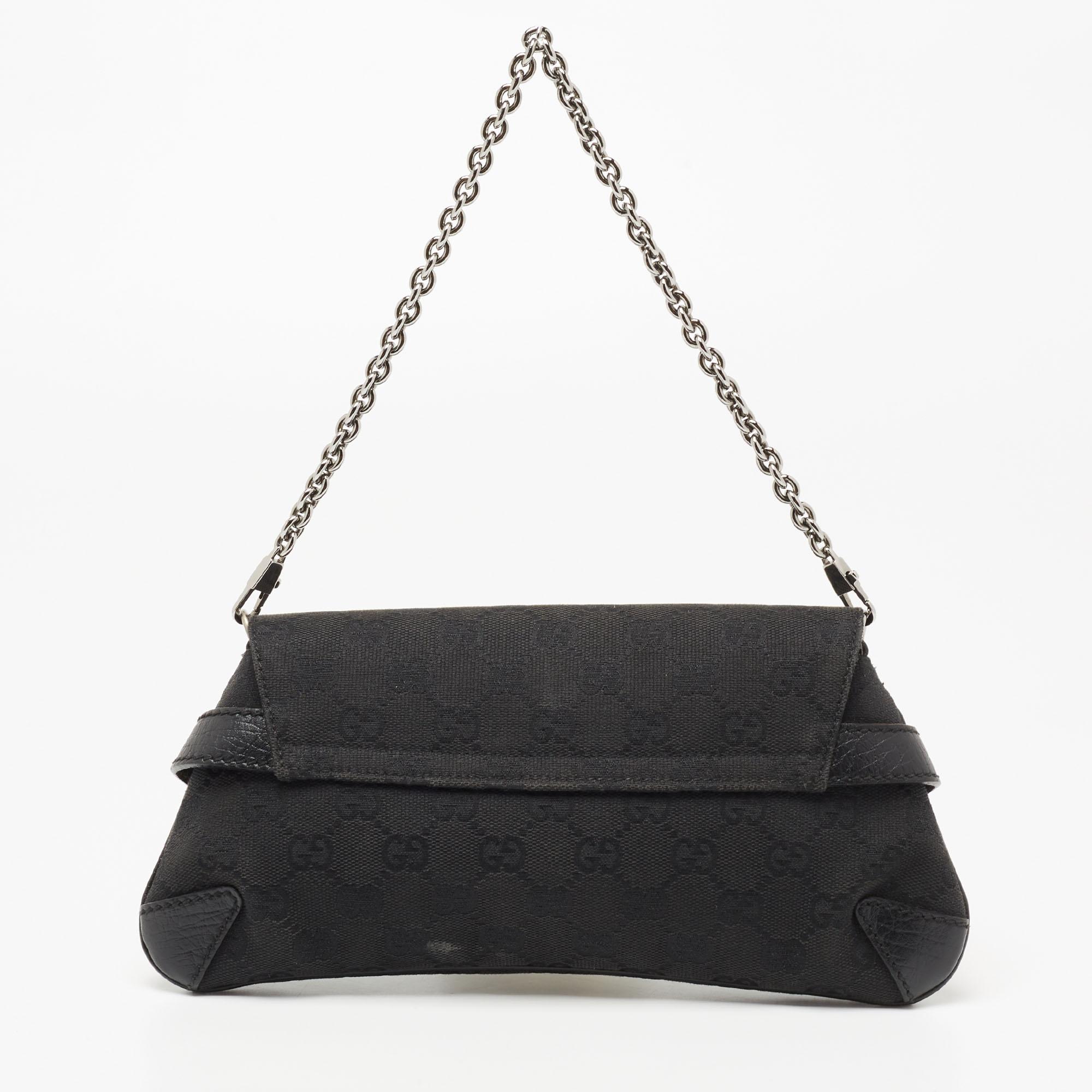This clutch from the House of Gucci is a stylish creation that is exceptionally well-made. Crafted from black GG canvas, this clutch is embellished with a Horsebit motif on the front. It unveils a fabric-lined interior, which can easily fit your