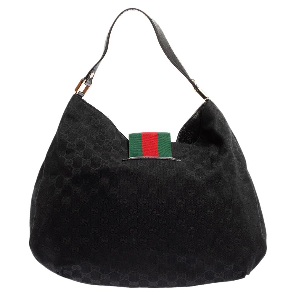 Crafted from GG canvas in Italy, this gorgeous bag from Gucci is a design that has never gone out of style. It has a flap styled as the label's iconic web stripe, and it opens up to a spacious fabric interior. Held by a single leather handle, this