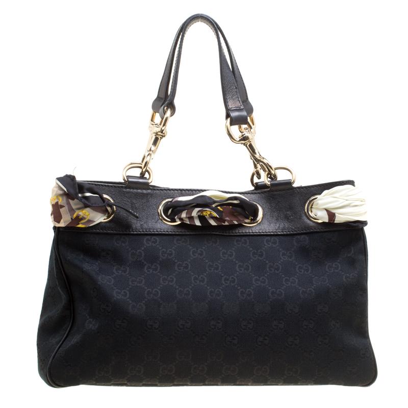This beautiful bag from Gucci is all that you need to instantly elevate your look. It is a stylish and functional GG canvas and leather bag that adds a high-fashion flair to any appearance. This charming bag comes with a fabric interior, a scarf