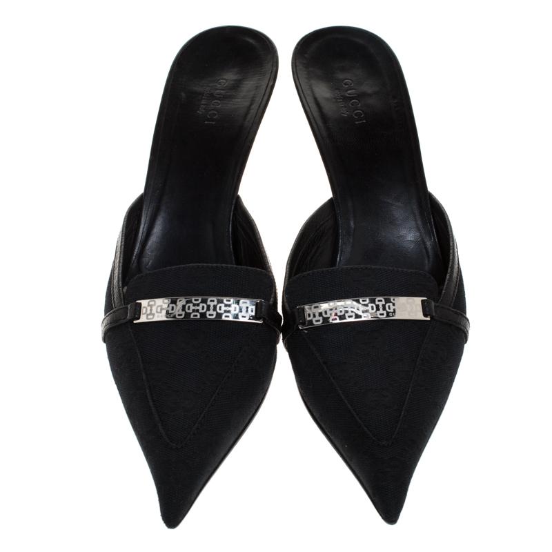 How trendy are these mules from Gucci! They carry a classic black exterior made from the signature CC coated canvas and have comfortable insoles. They are complete with pointed toes, metal accents on the vamps and low heels. Team them with your