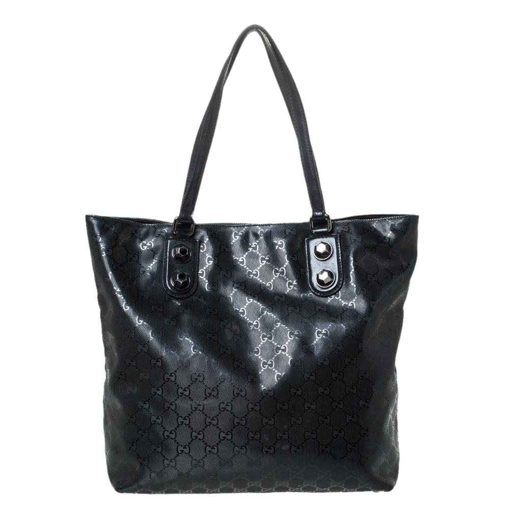 Head out anywhere with this fabulous tote bag by renowned Italian brand Gucci. Crafted from the brand's iconic GG Imprime monogram coated canvas, it carries a classic shade of black. This stylish tote features distinctive shoulder straps and the zip