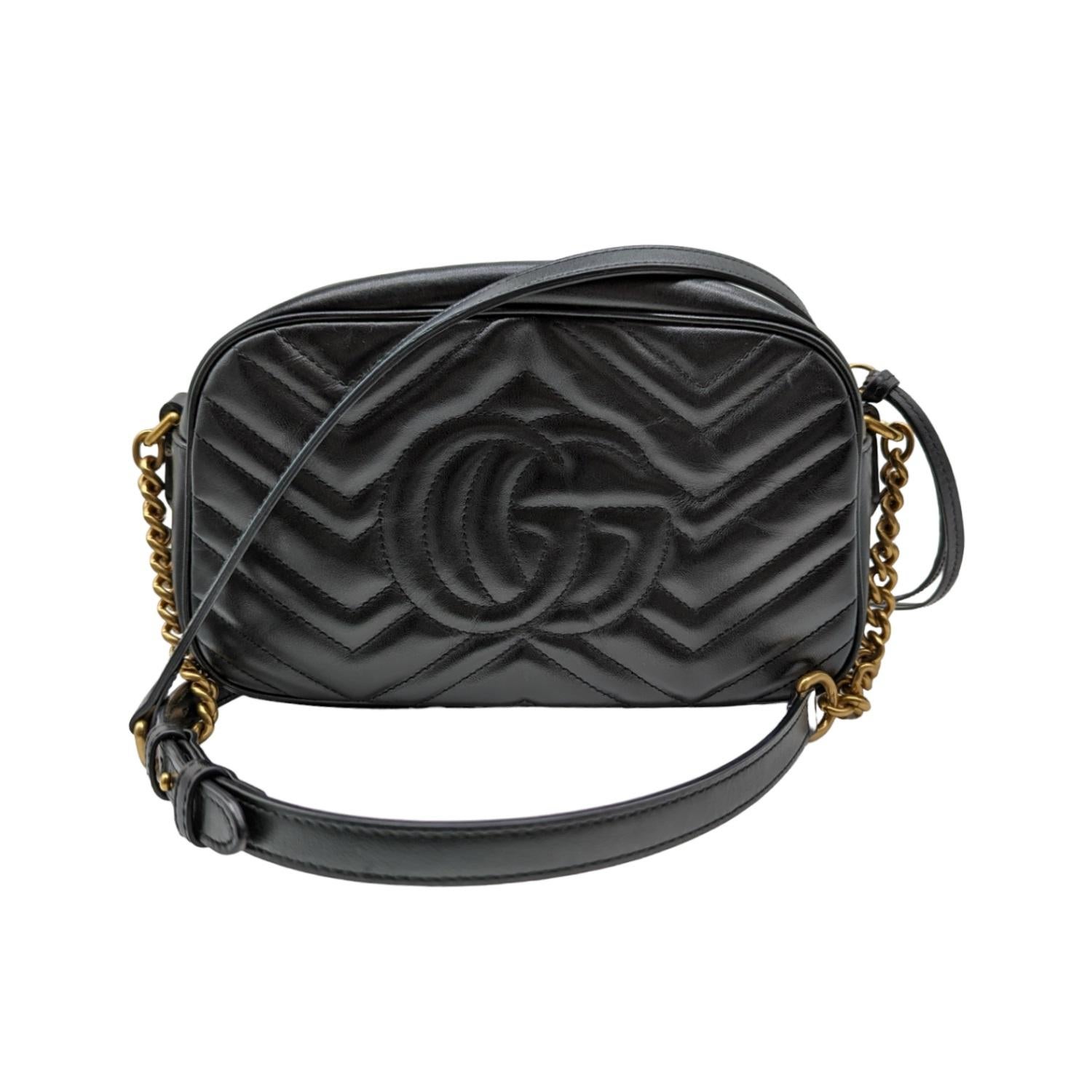 The small GG Marmont chain shoulder bag has a softly structured shape and a zip top closure with the Double G hardware. The chain shoulder strap has a leather shoulder detail. The camera bag is made in matelassé leather with a chevron design and GG