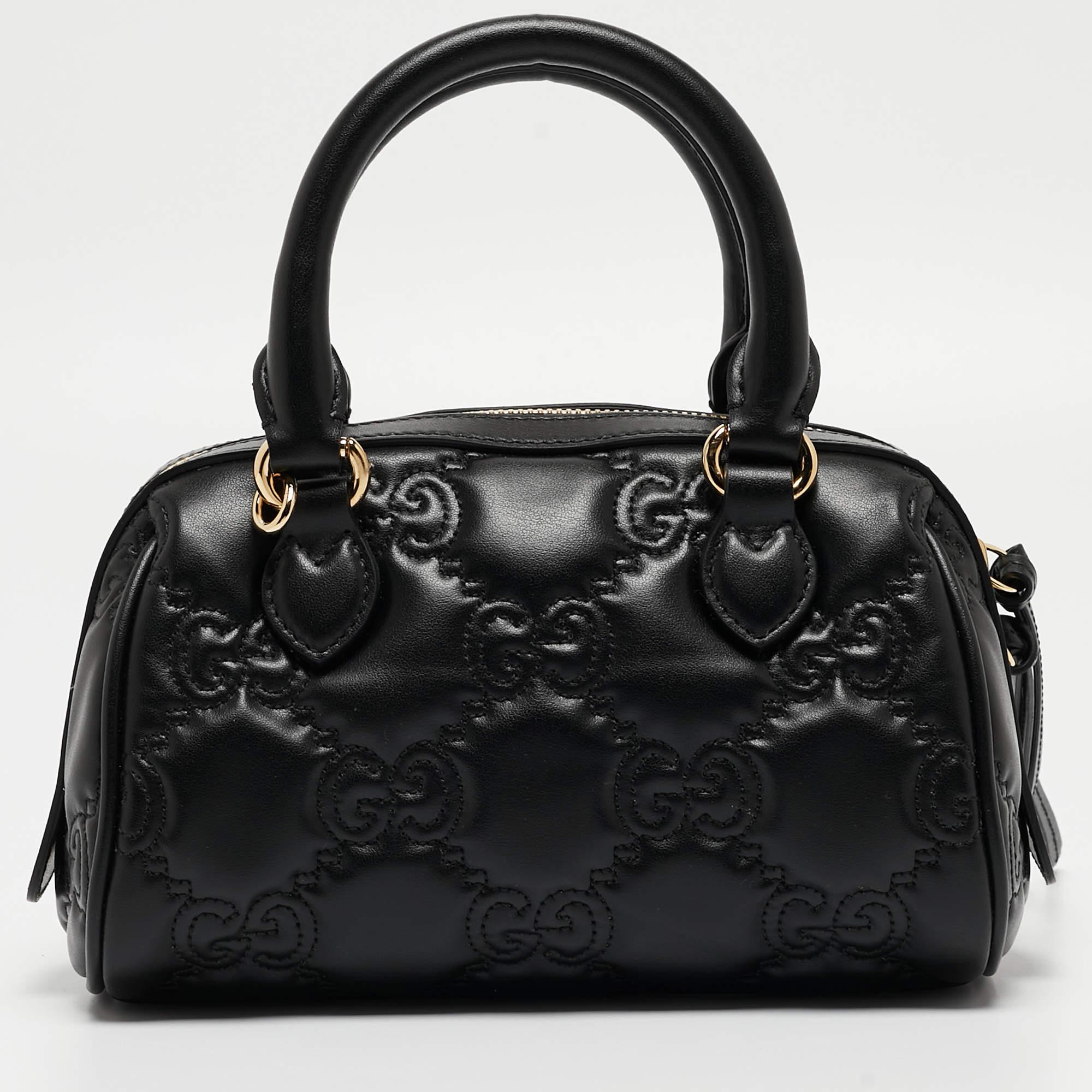 The Gucci bag exudes luxury with its quilted design and iconic GG monogram. Crafted from smooth leather, it features a compact size, gold-tone hardware, top handles, and a chain strap. The matelassé stitching adds texture, making it a sophisticated