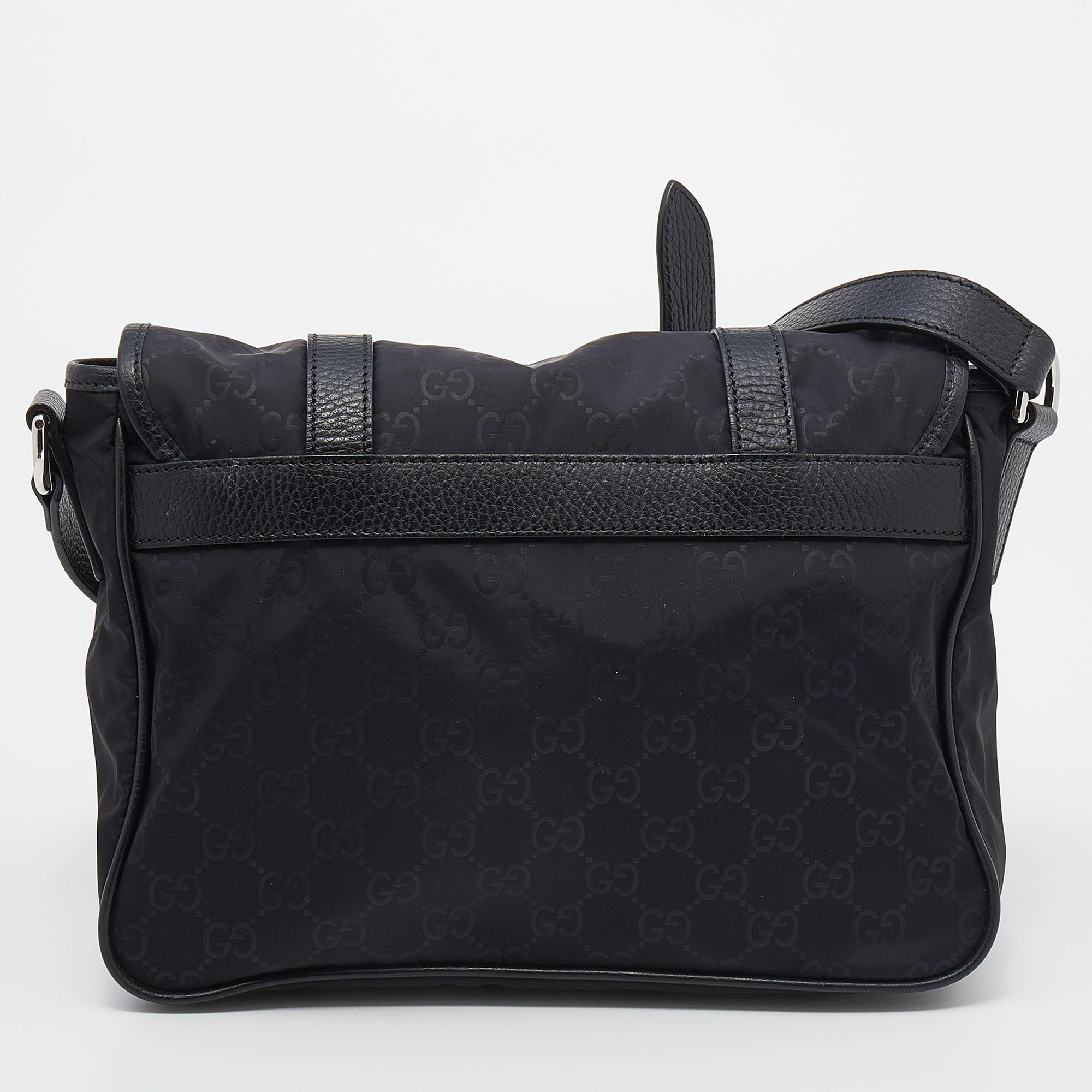 This messenger bag from the House of Gucci is absolutely classy and practical! Made from black GG nylon and leather, this bag features a shoulder strap along with silver-tone hardware. It accommodates a roomy fabric-lined interior. Carry this Gucci