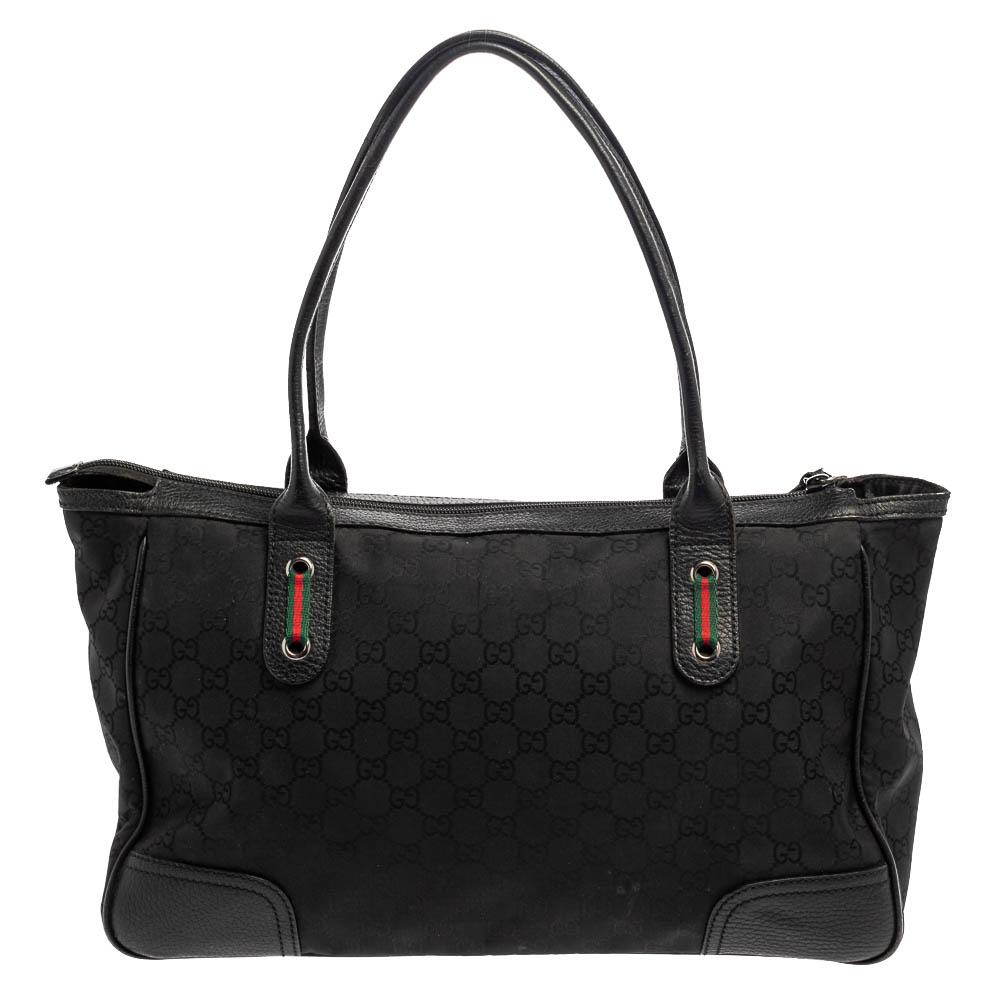Crafted from GG nylon and leather, this bag from Gucci is designed with minimal style details but with high attention to craftsmanship so that it may assist you with durability. The spacious interior of the bag is lined with fabric and secured by a