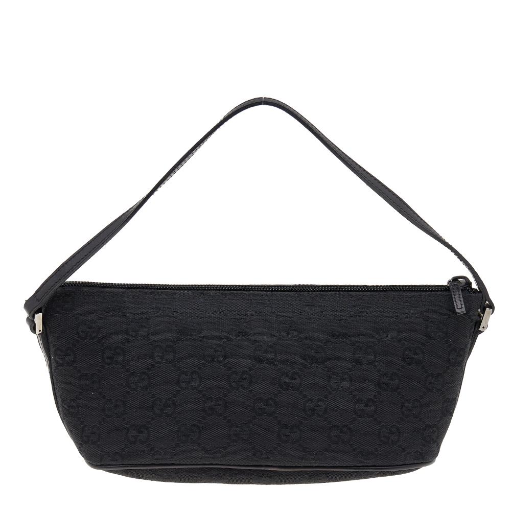 This handy Pochette bag was skillfully created by the House of Gucci. It has been made using the black signature GG canvas and leather on the exterior with a gunmetal-toned logo plaque perched on the front. It is equipped with a fabric interior that
