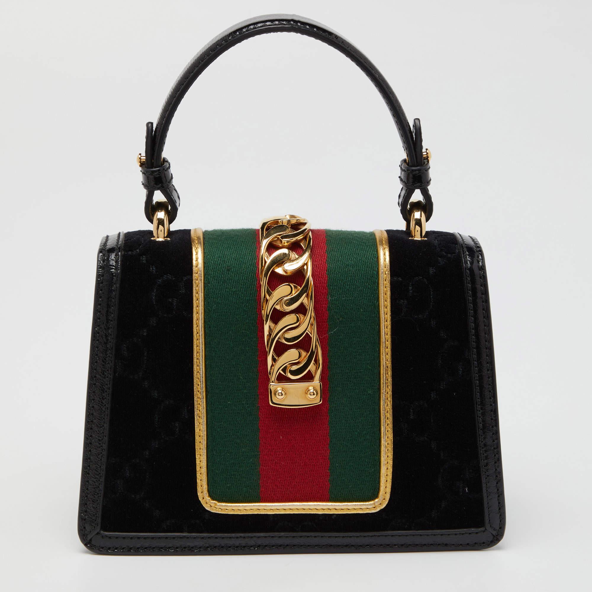 Alle Designs von Gucci, wie diese Sylvie-Tasche, spiegeln einen Sinn für Innovation und Tradition wider. Sie ist aus Leder mit dem Markenzeichen und einem auffälligen Flammendesign gefertigt und wird für ihr verführerisches Finish bewundert. Die