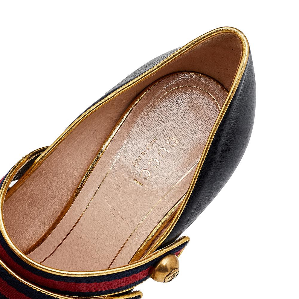 Inspired by the vintage Mary Jane style, the House of Gucci presents these beautiful Carly pumps. They are made in a Mary Jane style and show black-gold leather on the exterior, classic Web Stripe detailing, and distinct gold-toned hardware. Obtain
