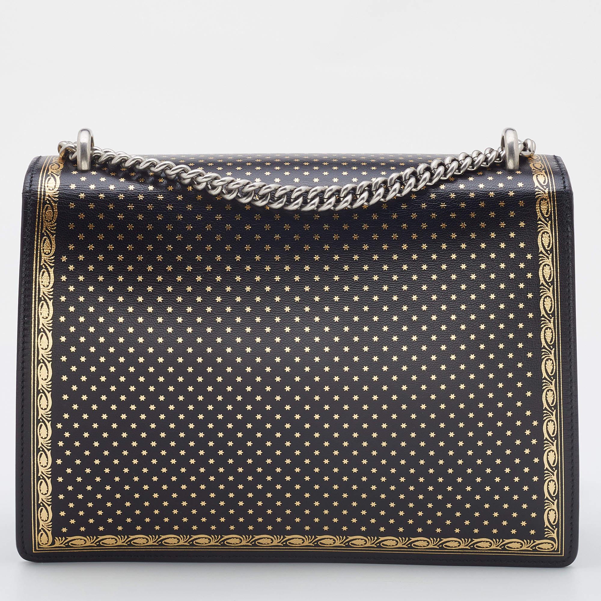 Gucci's statement Dionysus bag comes with an update of 'GUCCY'. Crafted from leather, the bag has a beautiful structure enhanced with signature details and gold patterns on black. A silver-tone chain and fabric compartments add to the utility of