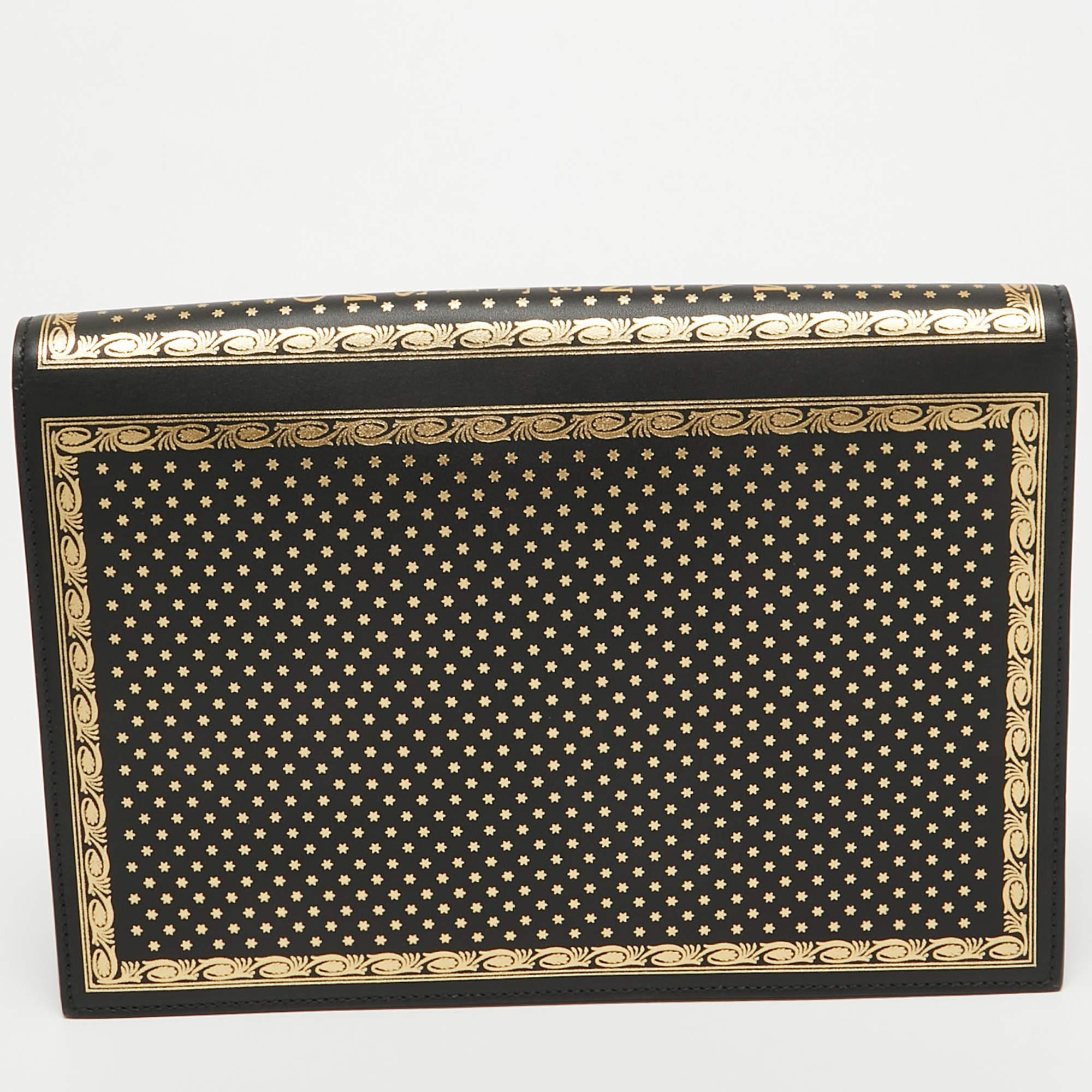The Gucci Portfolio Clutch exudes luxury with its smooth black leather adorned with gold GUCCY lettering. This sleek and spacious clutch is a sophisticated accessory, perfect for carrying essentials with style, showcasing the iconic Gucci