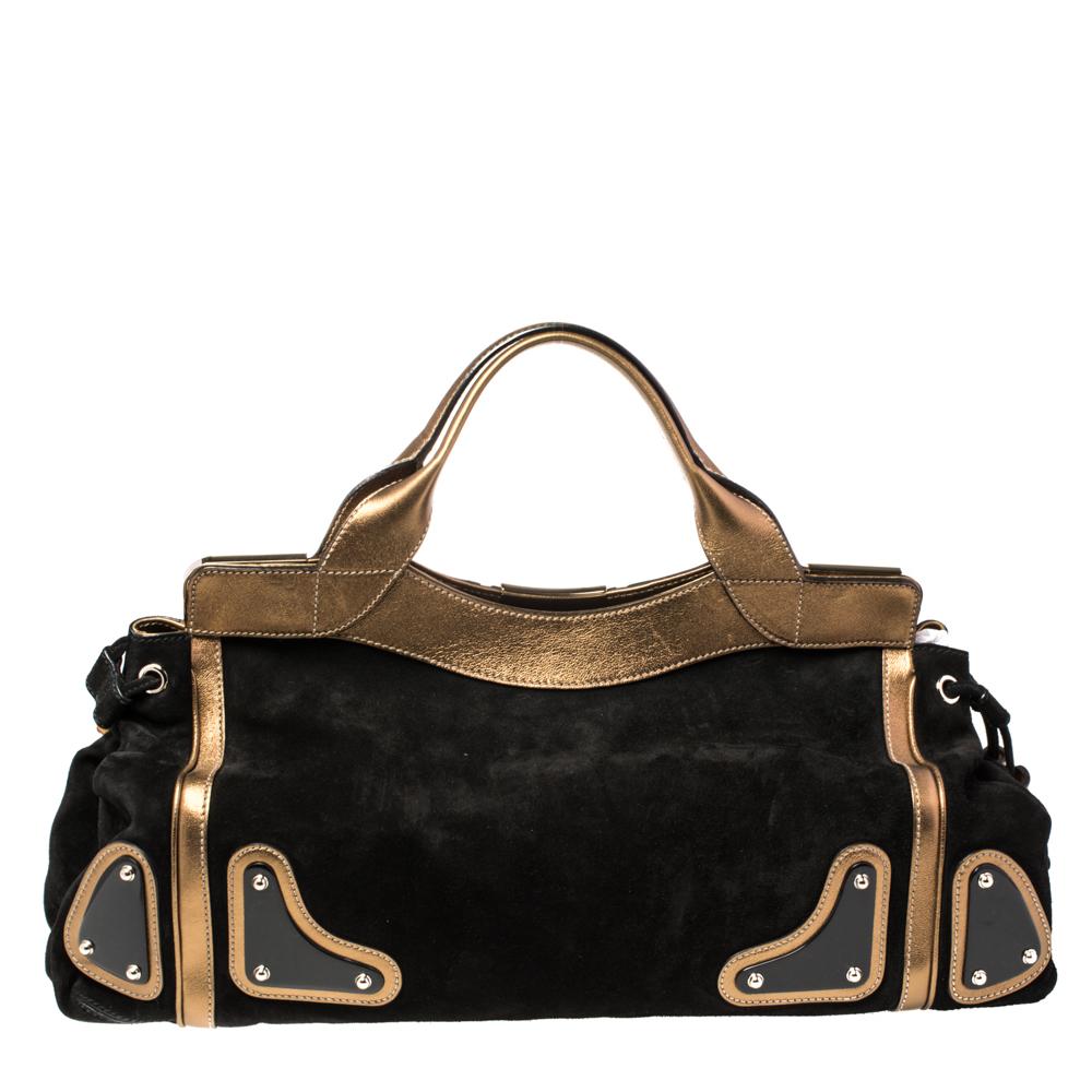 This spacious Race bag comes from the house of Gucci. The bag comes made from black suede and gold leather, with dual top handles, gold-tone metal accents, bamboo-detailed tassels, and a fabric interior.

Includes: Original Dustbag, Info Booklet