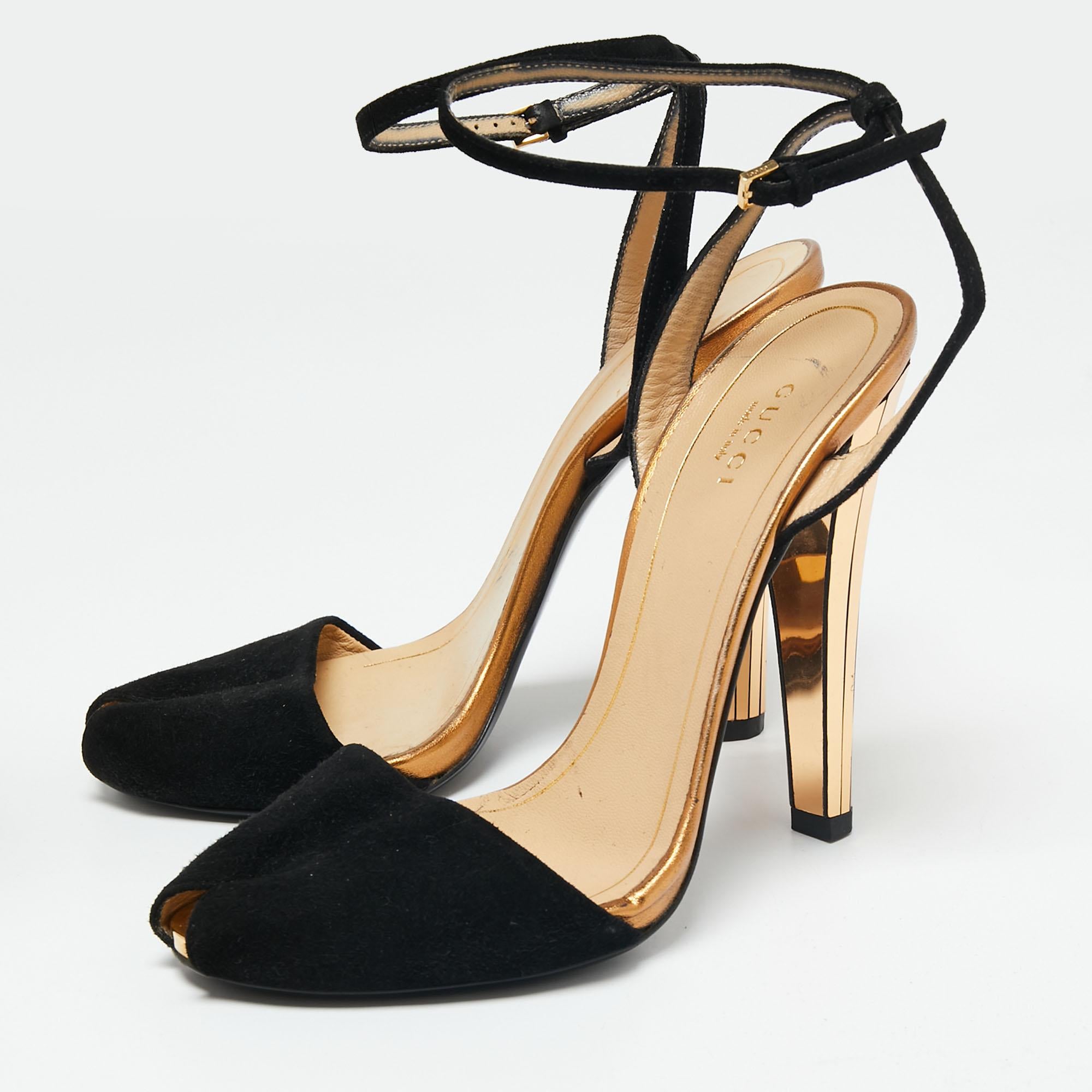 Walk stylishly as you flaunt these sandals from the House of Gucci. Designed using black-gold suede, these sandals are accentuated with 12 cm heels, an ankle strap, and open-toes. They feature gold-toned hardware. Match them with your outfits for a