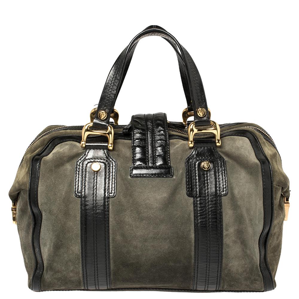 A truly posh and elegant piece to add to your collection. This Aviatris Boston bag by Gucci is coveted around the world It has been crafted in Italy and made from suede. It comes in lovely hues of black and grey. It is styled with a flap that