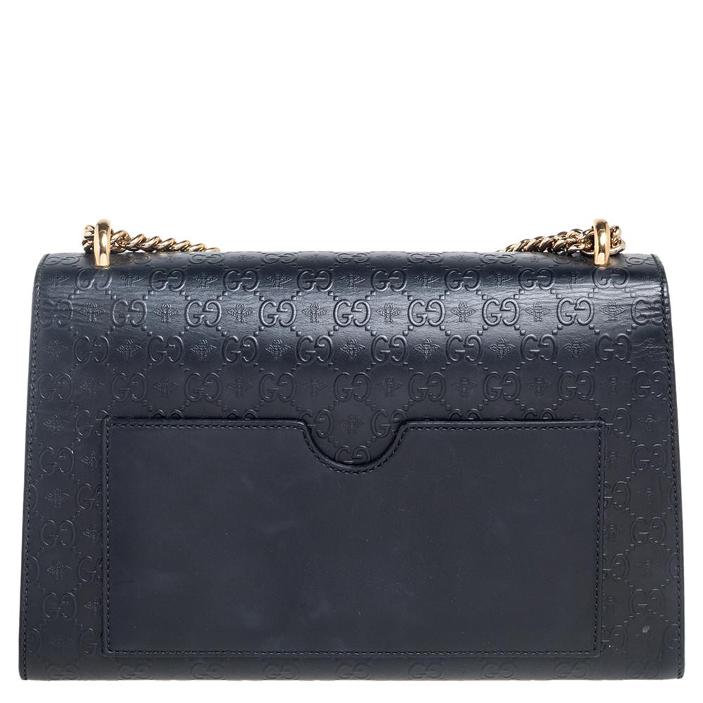 Swing this gorgeous bag and fetch endless compliments. This Gucci creation has been beautifully crafted from black Guccissima leather, embossed with bee motifs and a flap that carries a signature padlock. The insides are lined with fabric and sized