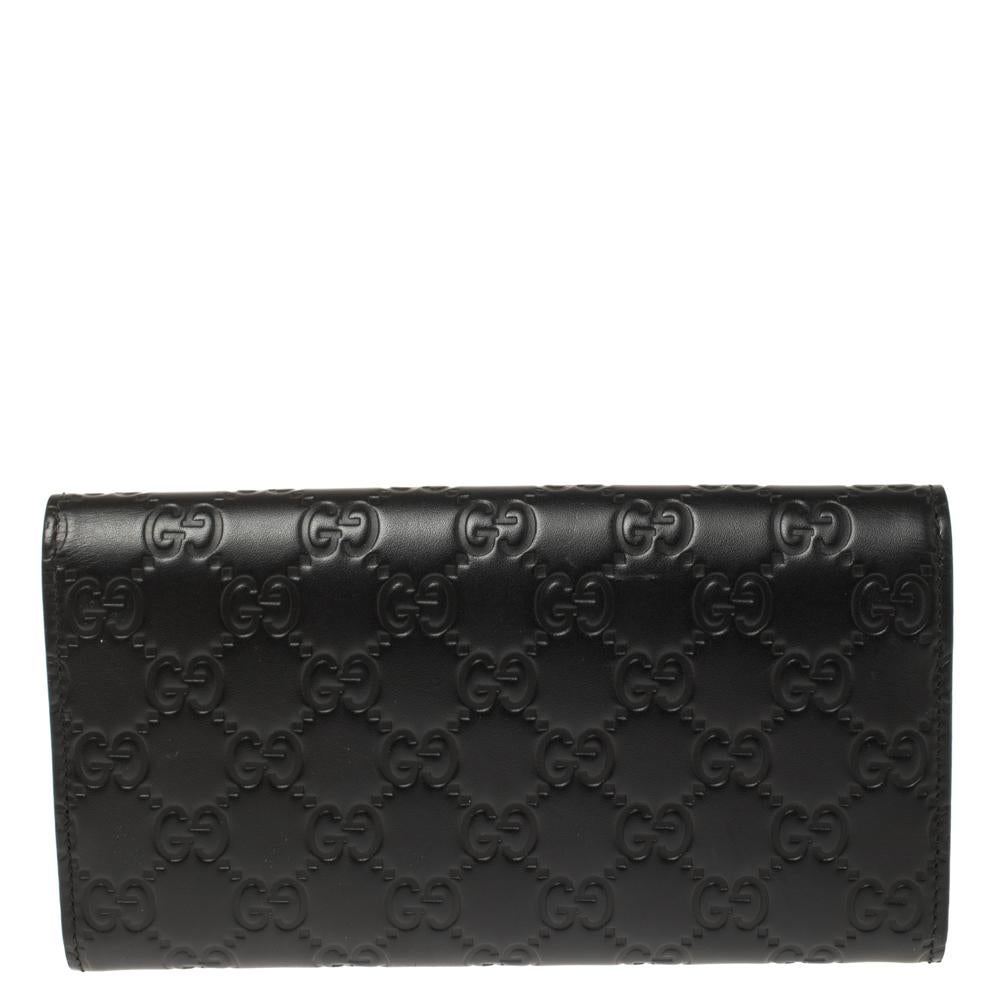 Dieses elegante und praktische Portemonnaie aus dem Hause Gucci ist aus dem für die Marke charakteristischen Guccissima-Leder in einem herrlichen Schwarzton gehalten. Das Portemonnaie mit Klappe ist mit einem Druckknopfverschluss versehen und trägt