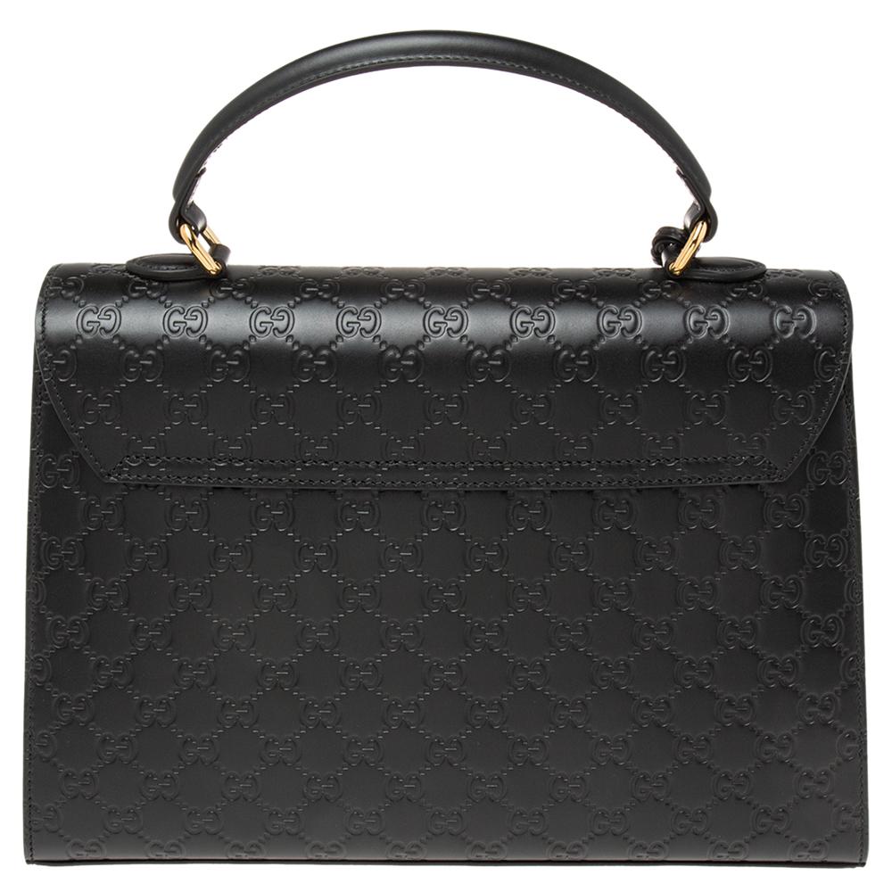 Pretty in black, this bag from Gucci is sure to add sparks of luxury to your wardrobe! It is crafted from the signature Guccissima leather and features a single top handle with an attached clochette. It flaunts a front flap with a gold-tone padlock