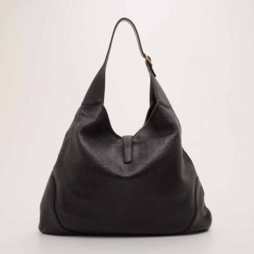 This stylish black leather New Jackie hobo by Gucci is a great no fuss bag for day. Crafted from soft GG printed leather in versatile black, this handbag features a piston strap closure and a single buckle detailed handle. The spacious interior is