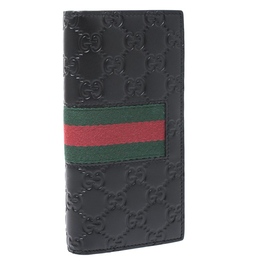This wallet is a suave creation from the house of Gucci. Crafted in Italy from the brand's signature Guccissima leather, this black wallet features the iconic web detail on the exterior. The wallet opens to a leather and fabric-lined interior with
