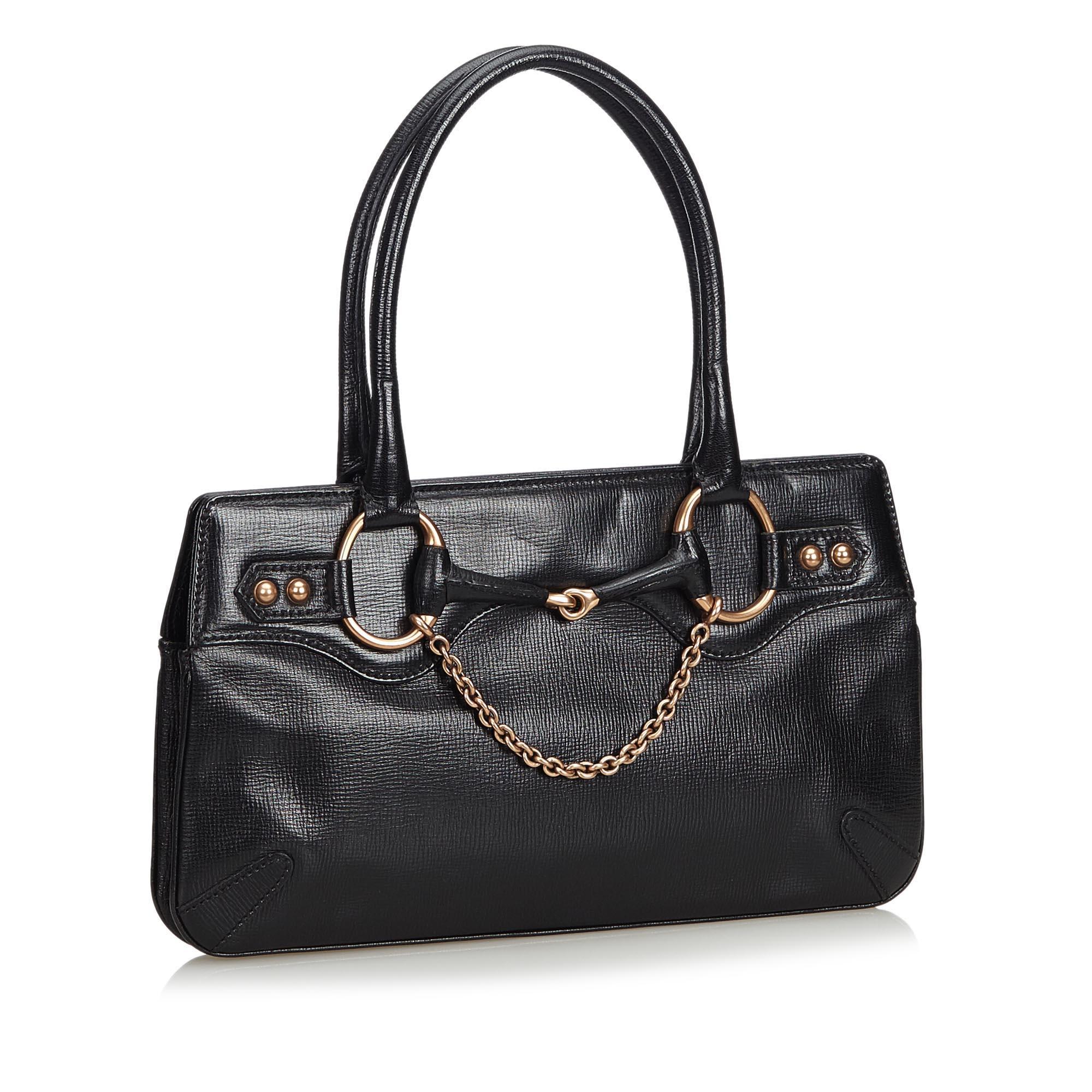This handbag bag features a leather body, rolled leather handles with chain and horsebit details, an open top with a magnetic closure, and an interior zip pocket. It carries as AB condition rating.

Inclusions: 
This item does not come with