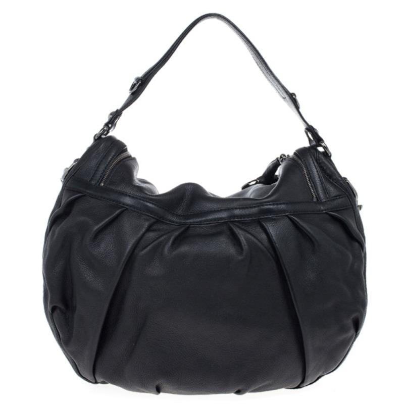 This casual everyday hobo by Gucci is crafted from slouchy black leather. Complemented with silver hardware, this Gucci hobo features a top flap zip closure and a leather lined interior with one zip pocket and one patch pocket. It features one