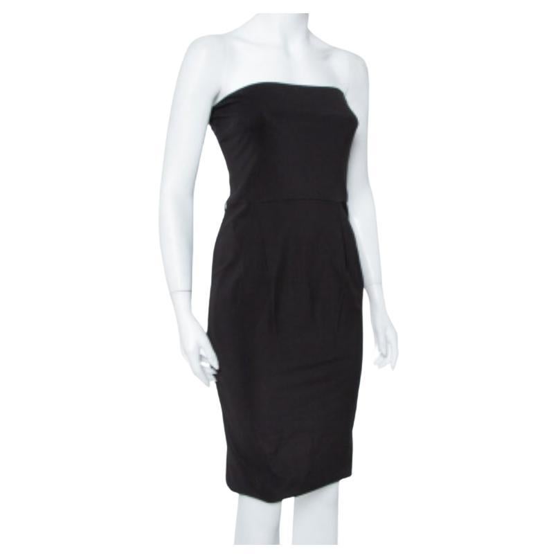 This Gucci dress spells minimal elegance in the best way with its sheath silhouette. Made from a blend of quality fabrics in a black hue, it features a strapless and pleated design secured by a rear zip fastening. Wear long dangling earrings to