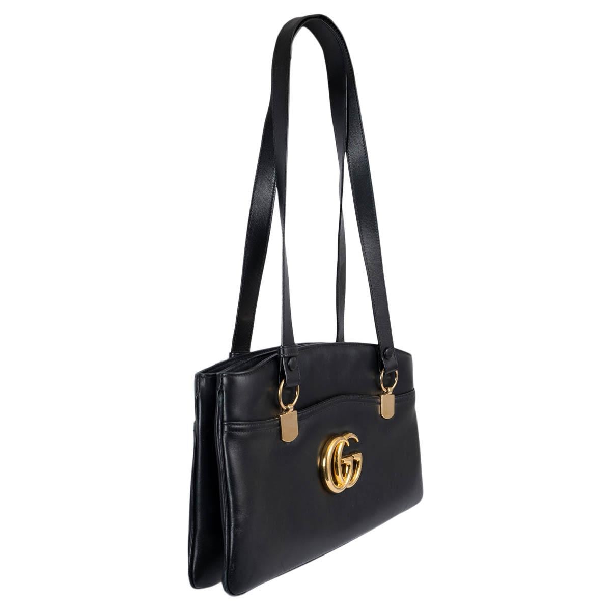 100% authentic Gucci Arli large tote in black calfskin featuring gold-tone hardware. The interior is divided in two compartment with zipper closure and lined in light pink grosgrain fabric with one zipper pocket against the back. The design features