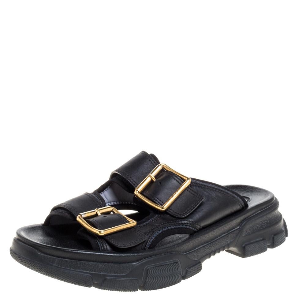 These stylish Gucci Aguru slide sandals are a perfect blend of comfort and style. Featuring a sturdy exterior made from leather, these black sandals are designed with dual gold-tone buckle straps and solid rubber platforms.


