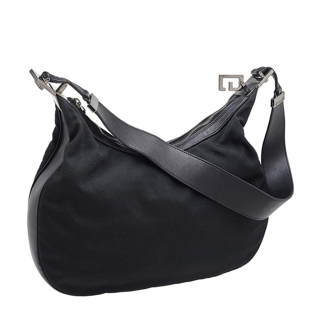 This beautifully stitched vintage hobo in leather and fabric is by Gucci. With a capacious fabric-lined interior, a comfortable shoulder handle, and a fine finish, this black hobo is bound to offer style and practical ease.

