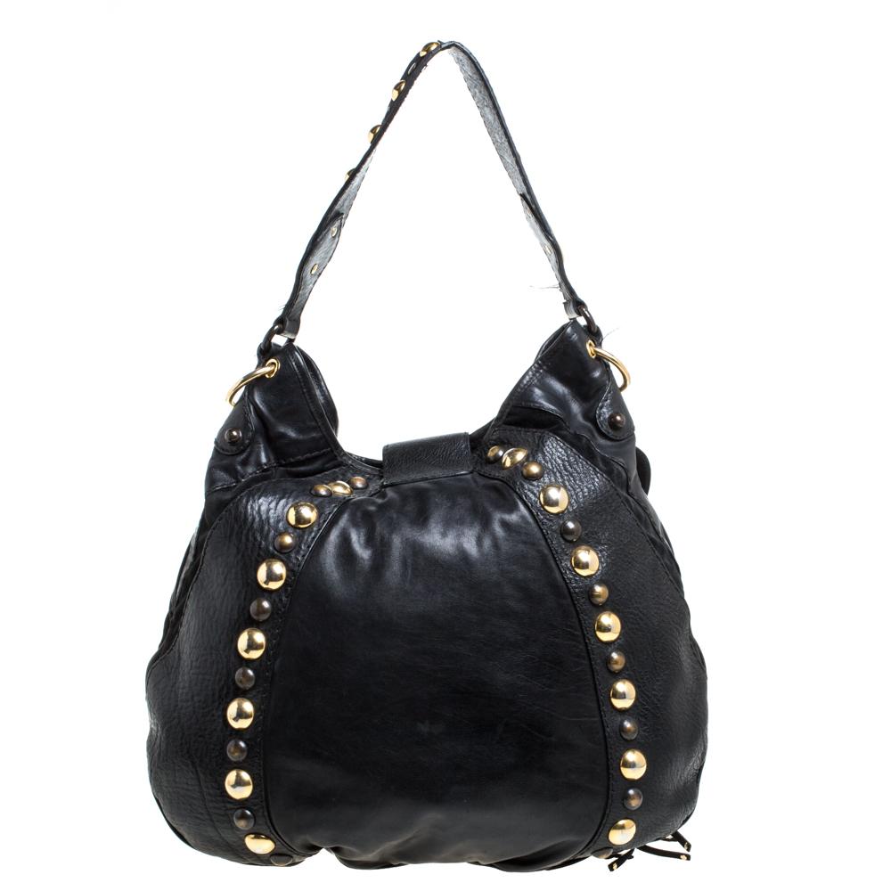 Crafted from leather and suede, this Gucci number has a single top handle and is decorated with multiple studs, fringe details, and signature emblems. It opens to a nylon-lined spacious interior that can easily accommodate your daily essentials.
