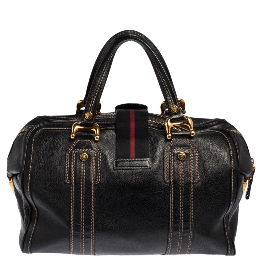 Here's something to help you travel in style! This Boston bag from the house of Gucci is designed to carry your everyday essentials with ease. A chic black shade enhanced with gold-toned metal accents and buckles makes this bag a classy traveling