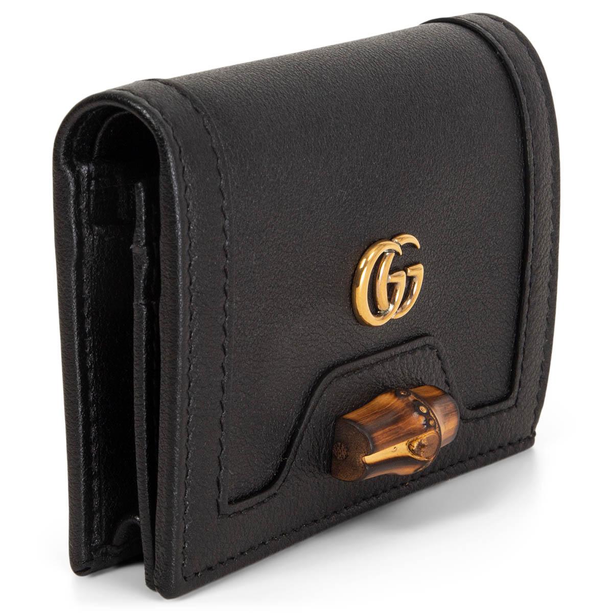 100% authentic Gucci mini wallet in balck calfskin finished with bamboo detailing, this accessory embodies the Italian brand's heritage with an iconic gold-tone GG logo plaque on the front. Opens with a push-buttons and is lined in black nylon.