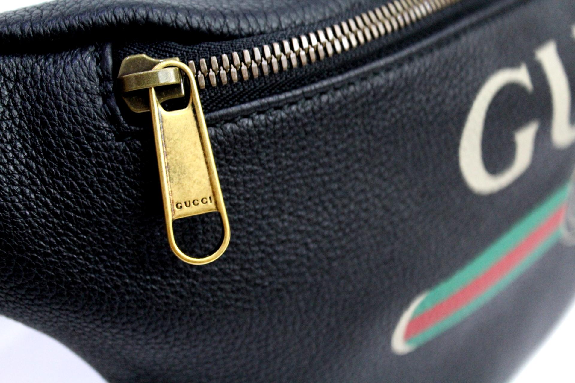 Gucci belt bag made in leather with front zipper and vintage logo. Nylon belt with red and green web pattern.