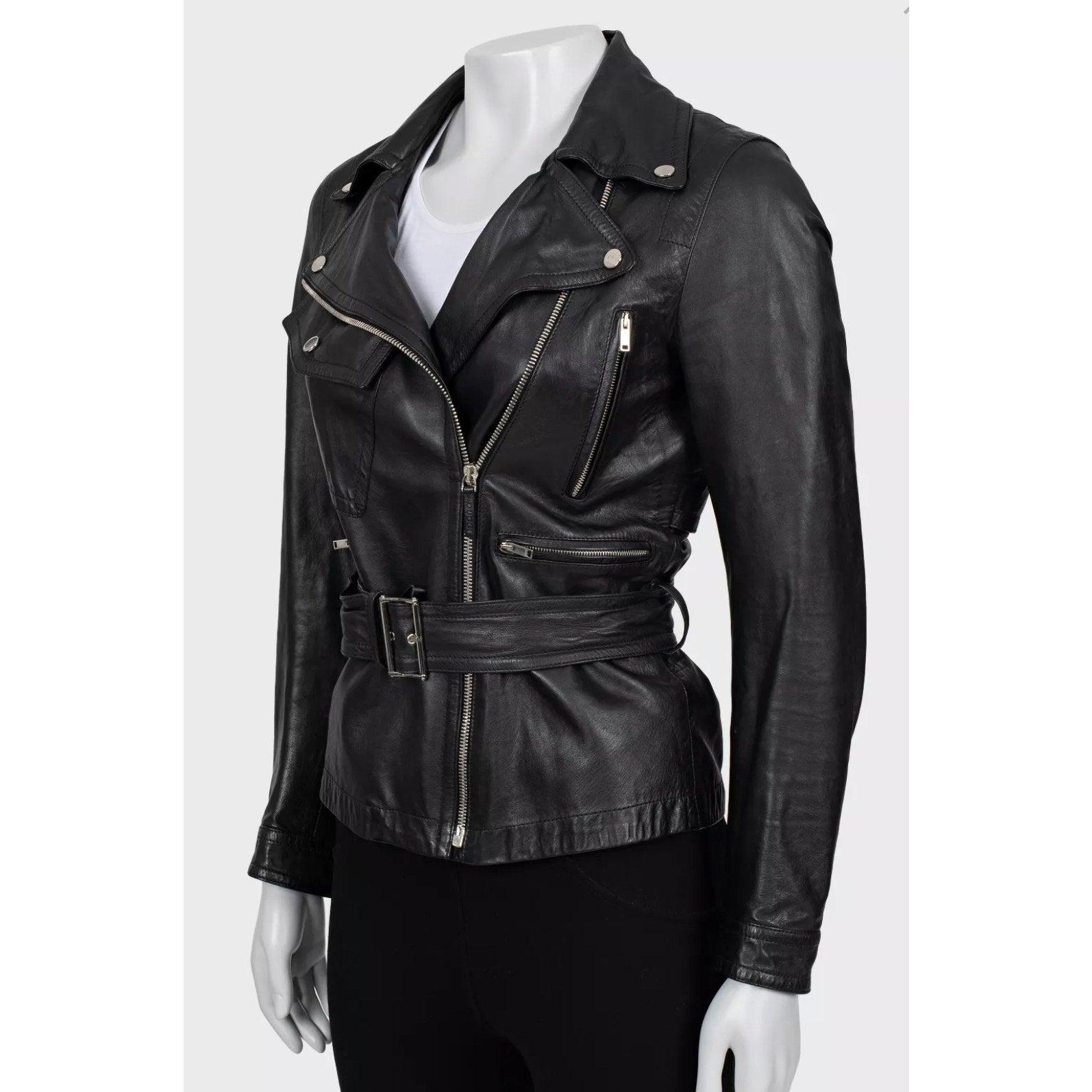 Eleva il tuo guardaroba con questa elegante e sofisticata giacca in pelle nera di Gucci. 
Realizzata al 100% in vera pelle, questa giacca presenta un'elegante silhouette aderente con cintura in vita. 
La minuteria argentata aggiunge un tocco di