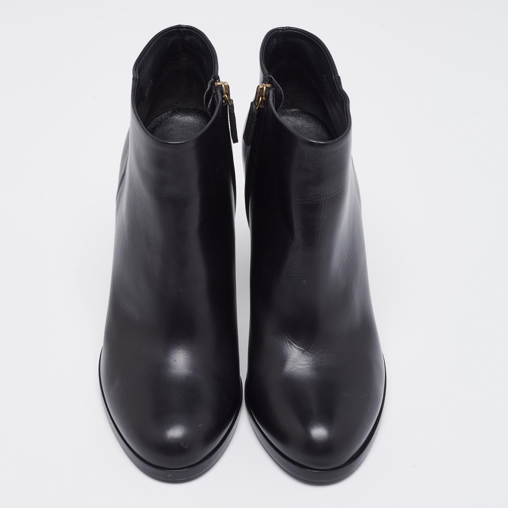 La Maison Gucci apporte raffinement et grâce à votre garde-robe avec ces superbes bottes. Ils sont confectionnés en cuir noir et forment une silhouette longue comme la cheville. Elles sont dotées d'une fermeture à glissière, de matériel de couleur