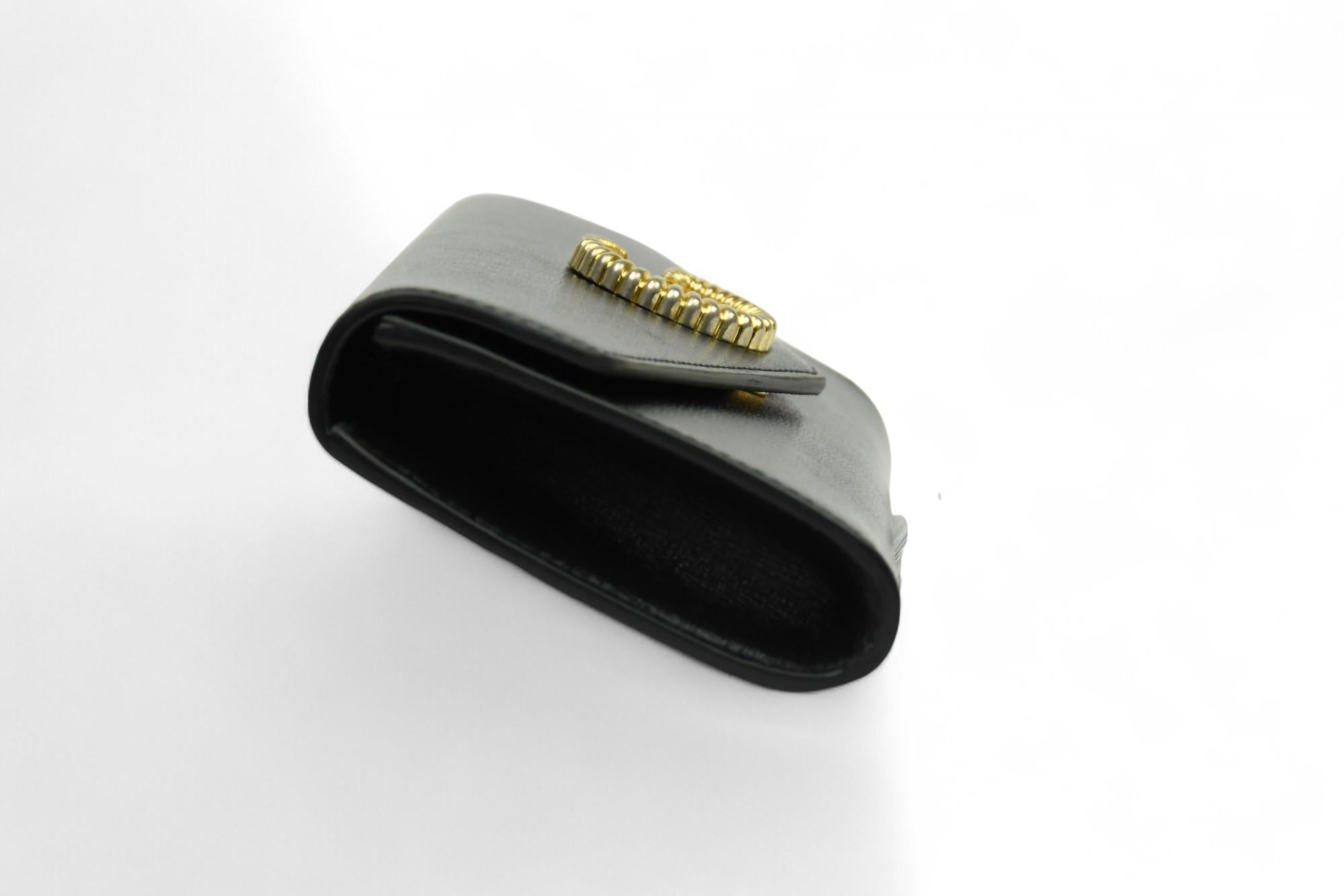 Elegante e strutturata, questa pochette Broadway di Gucci è realizzata in pelle nera liscia ed è impreziosita dall'emblema GG della maison con un'audace minuteria dorata. La sua silhouette a busta si apre su un interno dai toni neutri perfetto per