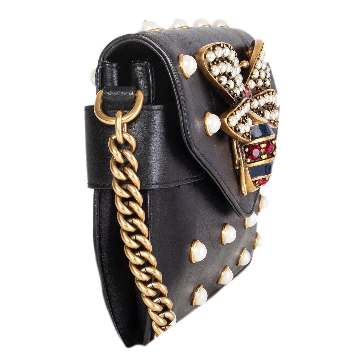 Gucci 'Broadway Pearly Bee' shoulder bag in black calfskin embellished with a antique gold-tone metal bee, pearls and crystals. Features chain link strap and blue, red and white singnature Web shoulder strap. Its flap closure opens to a tan leather