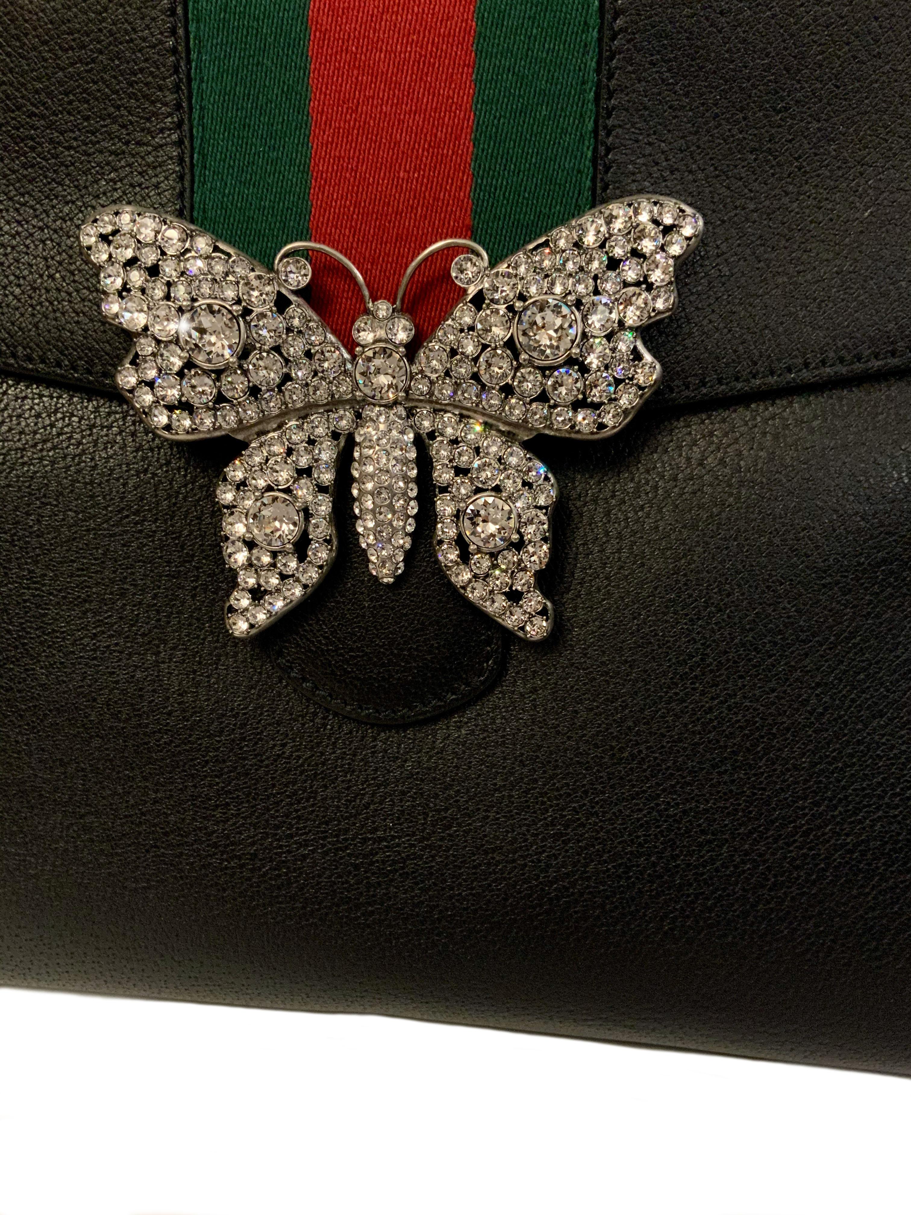 This pre-owned bag from Gucci is crafted in black calfskin leather.
It features a beautiful crystal butterfly on the front with a signature Gucci web detail on the flap, a rear pocket and a middle snap closure. 
Its optional canvas shoulder strap