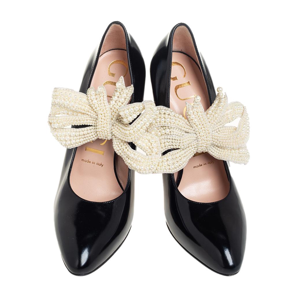 Be ready for constant attention and admirable glances from your audience when you walk in these pumps from Gucci. Crafted from black leather, they carry almond toes and flaunt pearl-embellished removable bow straps. The pair is complete with 12.5 cm