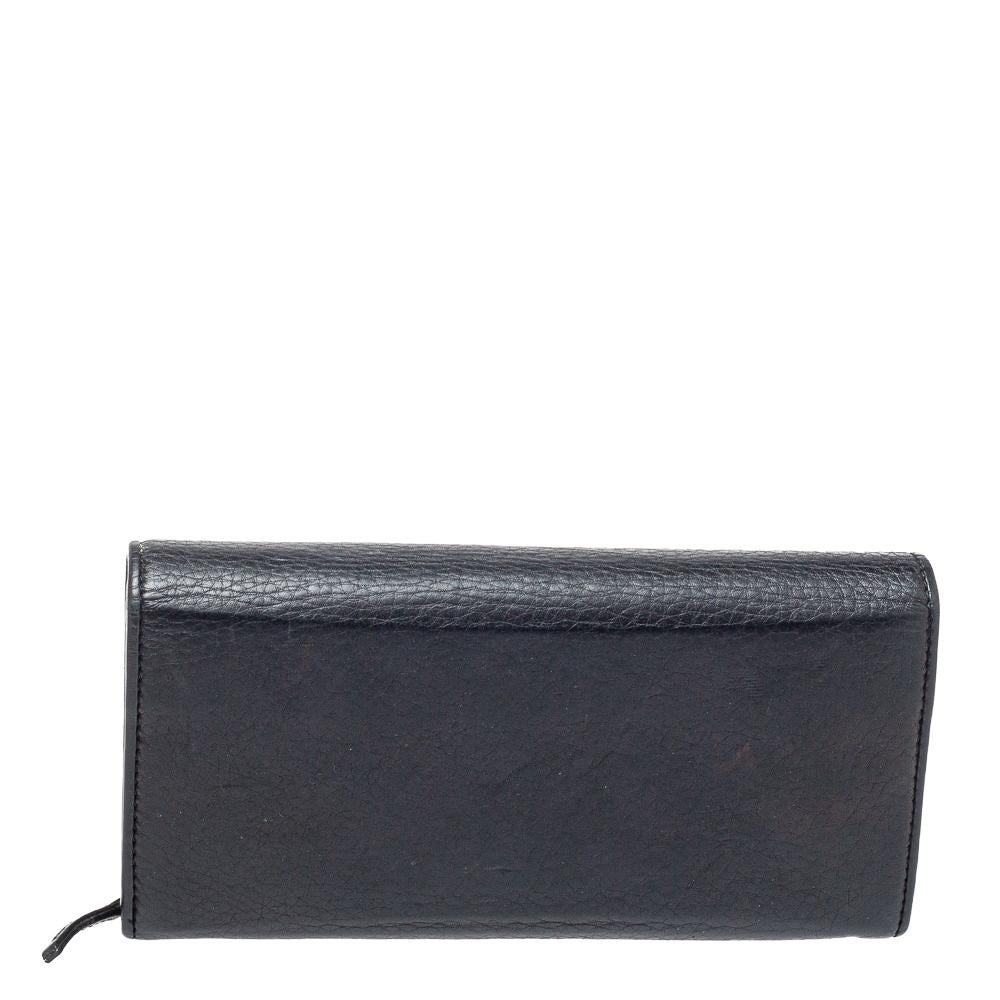 Durable and long-lasting, this black 1973 continental wallet from Gucci is crafted from leather. Showcasing an exclusive design, it makes for a stylish as well as a convenient accessory. It flaunts a gold-tone GG logo on the front flap and opens to