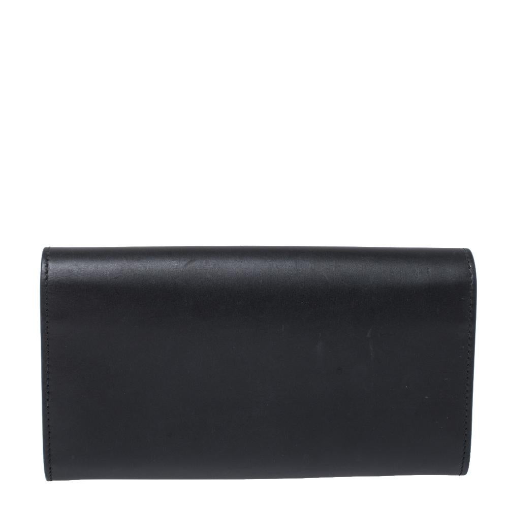 A suave creation from the house of Gucci. Featuring a leather exterior, this wallet is a convenient accessory with a zip pocket, multiple card slots and a full flap with snap-button closure. The classic black hue of this stylish wallet with a bold