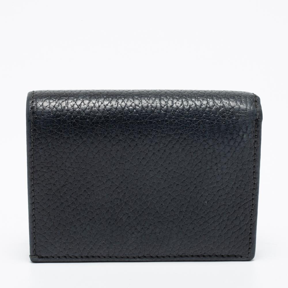 Keep your monetary essentials in an organized way with this GG Marmont compact wallet from the House of Gucci. It is made from black leather, with a GG motif perched on the front. It is elevated with gold-tone hardware and opens to a spacious
