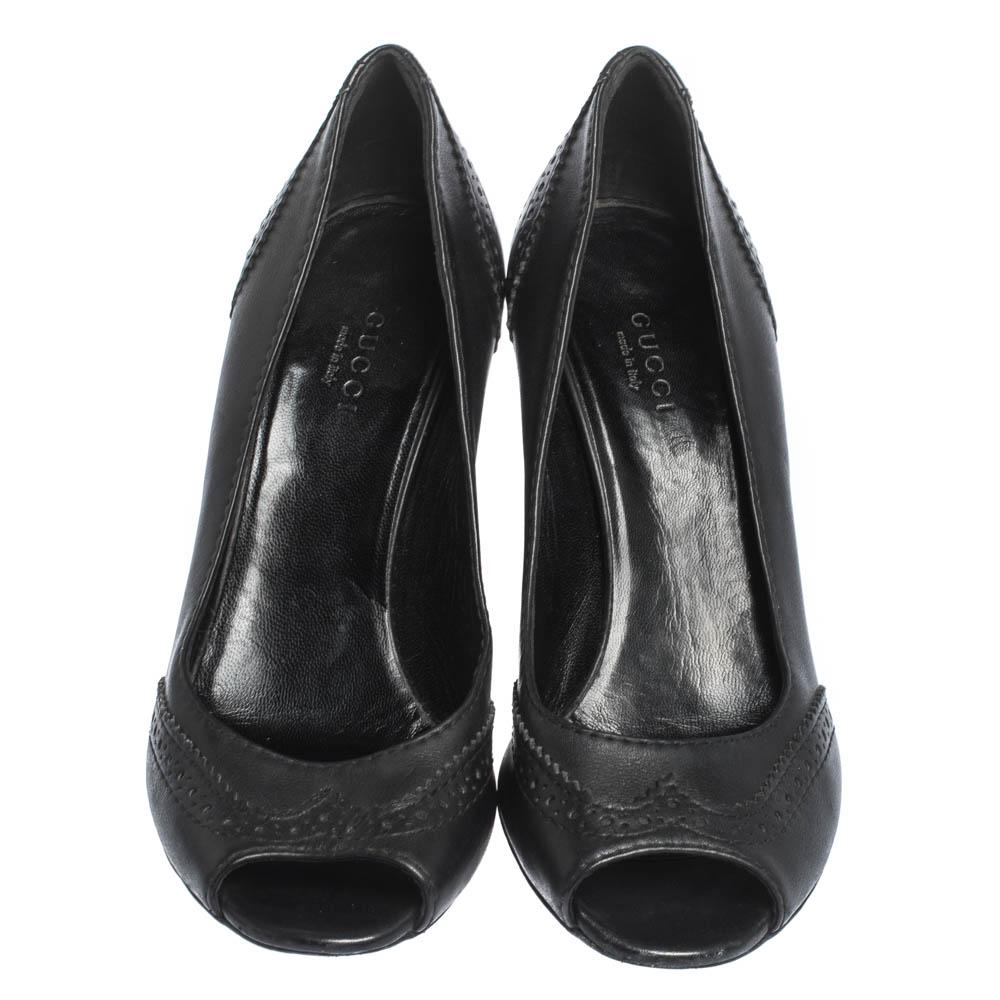 Pair that stylish formal outfit with these Gucci wedge pumps to deliver sophistication. Crafted in black leather, these feature peep toes, brogue detailing, GG pattern on the 8 cm wedges. Insoles are leather-lined and carry the brand label. A