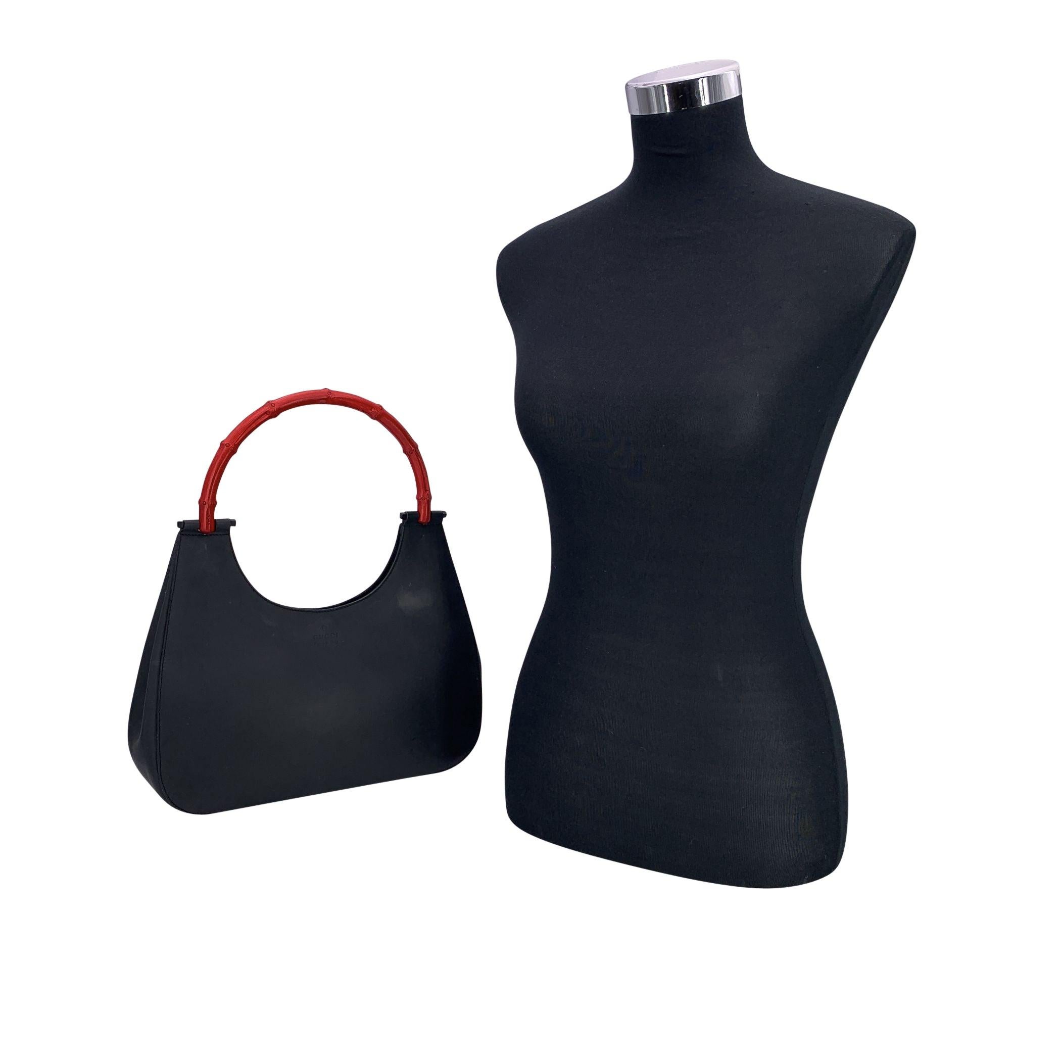 Bellissima borsa hobo di Gucci, realizzata in pelle nera con manico in bambù, dipinta di rosso. La borsa presenta la scritta 