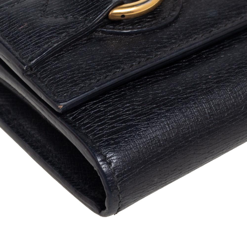 Brimming with brand details and excellence, this continental wallet from the House of Gucci will grant you signature style and beauty. It is made from black leather with a gold-toned Horsebit motif perched on the front. It opens to a leather-fabric