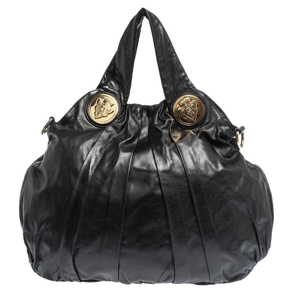 This stunning Gucci hobo is built for everyday use. Crafted from quality leather, it has a classic black exterior and two handles for you to easily parade it. The nylon-lined interior is sized well and the hobo is complete with the signature emblems