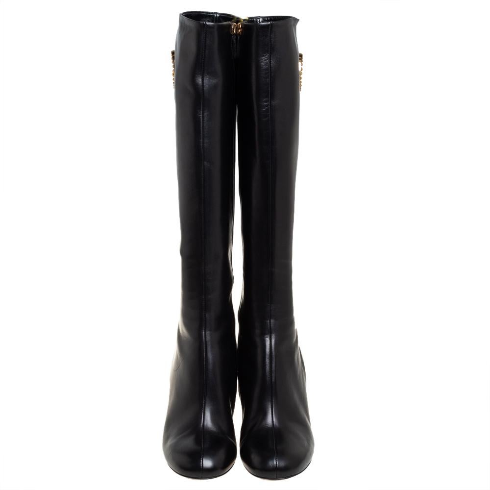 One can expect Gucci to deliver classic styles that become favorites in one's closet. These black knee-length boots for women are a fine example. Made from leather, they feature round toes, 9 cm heels, and the GG detail in gold-tone