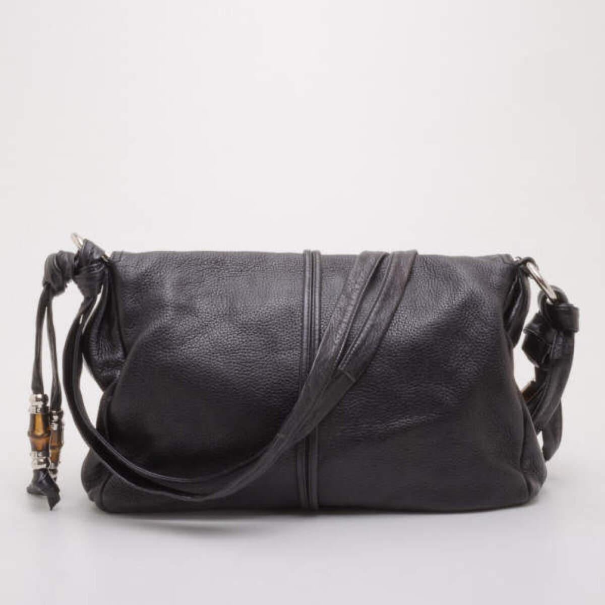 This Jungle messenger by Gucci is not your average black handbag. Crafted from supple black leather, it is accented with Gucci's signature bamboo accents, chic tassels and silver hardware. The interior is lined with Gucci monogram canvas, two
